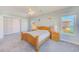 Bright bedroom with carpet, ceiling fan, and two windows with views of the community at 250 Seagate Ct, Dunedin, FL 34698