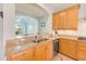 Kitchen counter featuring granite, stainless appliances and an open view of the living room at 250 Seagate Ct, Dunedin, FL 34698