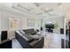 Open-concept living room with coffered ceilings, large windows, and a modern fireplace at 250 Seagate Ct, Dunedin, FL 34698