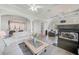 Open-concept living space with fireplace, comfortable sofas, and access to the kitchen at 250 Seagate Ct, Dunedin, FL 34698