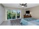 Bright bedroom with large sliding glass doors to a balcony, ceiling fan, and wood dresser at 2699 Seville Blvd # 808, Clearwater, FL 33764