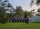 Lush lawn, trees, and building exterior with a tile roof and arched walkways at 2699 Seville Blvd # 808, Clearwater, FL 33764