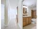 Hallway view into bathroom with brown cabinets and tile bathtub at 3105 S Canal Dr, Palm Harbor, FL 34684