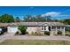 A tan single-Gathering home has a well-kept lawn, a front porch, and an attached garage at 3105 S Canal Dr, Palm Harbor, FL 34684