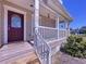 Inviting front porch featuring classic white railing and a decorative front door with glass detailing at 3105 S Canal Dr, Palm Harbor, FL 34684