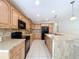Kitchen with black appliances, oak cabinets, and bar seating, perfect for casual dining and entertaining at 3105 S Canal Dr, Palm Harbor, FL 34684