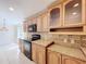 Kitchen featuring oak cabinetry, black appliances, and granite countertops, offering both style and functionality at 3105 S Canal Dr, Palm Harbor, FL 34684