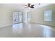 Spacious living room with tile floors, ceiling fan, and sliding glass doors to the patio at 3105 S Canal Dr, Palm Harbor, FL 34684