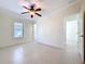 Bedroom with tile floors, ceiling fan, and a large window at 3105 S Canal Dr, Palm Harbor, FL 34684
