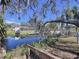 Backyard waterfront view featuring a canal, dock, screened lanai, and boat lift at 3105 S Canal Dr, Palm Harbor, FL 34684