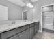 Elegant bathroom features dual sinks, gray cabinetry, a large mirror, and a separate shower and toilet room at 4204 Bonfire Dr, Odessa, FL 33556