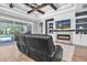 Living room showcasing a fireplace, custom built-ins, hardwood floors and a view to the pool at 4204 Bonfire Dr, Odessa, FL 33556