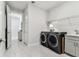 A modern laundry room with new washer and dryer units, storage, and sink at 4574 Freccia Loop, Wesley Chapel, FL 33543