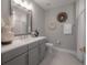 Bathroom with a quartz countertop, gray vanity, and a decorative mirror and wall decor at 5351 Bridge St # 99, Tampa, FL 33611