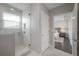 Bright bathroom featuring a tiled shower with glass door and a view into the bedroom at 5351 Bridge St # 99, Tampa, FL 33611