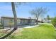 Beautiful backyard featuring a well-manicured lawn, mature trees, and a glimpse of the neighboring house at 5560 Frances Ave, New Port Richey, FL 34653