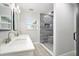 Modern bathroom featuring a double sink vanity, stone-tiled shower with built-in niche, and wood-look floors at 5560 Frances Ave, New Port Richey, FL 34653