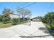 Long driveway leading to a charming home and garage with a mix of stone and metal at 5560 Frances Ave, New Port Richey, FL 34653
