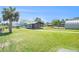 View of a compact building with a covered porch set on a lush green lawn near a canal at 5560 Frances Ave, New Port Richey, FL 34653