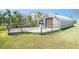 Unique metal building with a wooden deck and a well-maintained lawn at 5560 Frances Ave, New Port Richey, FL 34653