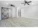 Open living space with barn door and wood-look flooring throughout at 5560 Frances Ave, New Port Richey, FL 34653
