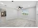 Modern living room with neutral walls, wood-look floors, and a view of the front yard at 5560 Frances Ave, New Port Richey, FL 34653