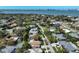 A high-angle aerial view showcasing a beautiful neighborhood with lush landscaping near bay waters and distant city skyline at 609 Osceola Rd, Belleair, FL 33756