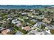 Stunning aerial view of neighborhood homes, lush greenery, and bay water with skyline in the distance at 609 Osceola Rd, Belleair, FL 33756