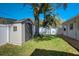 Spacious backyard with mature trees, green grass, and a storage shed, perfect for outdoor activities at 609 Osceola Rd, Belleair, FL 33756