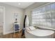 Relaxing bathroom with freestanding tub, stylish fixtures, and sunlit window at 609 Osceola Rd, Belleair, FL 33756