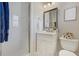 Bright bathroom features a walk-in shower with white tile and vanity with framed mirror at 609 Osceola Rd, Belleair, FL 33756