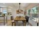 Charming dining area features a wooden table, modern lighting, and a large window for natural light at 609 Osceola Rd, Belleair, FL 33756