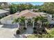 Beautiful home featuring a well-manicured lawn, mature palm trees, and a charming front porch at 609 Osceola Rd, Belleair, FL 33756