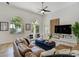 Stylish living room with large windows, modern furniture, and a contemporary ceiling fan at 609 Osceola Rd, Belleair, FL 33756