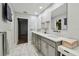 Well-lit bathroom with a double vanity, white countertops, and marble-look tile floor at 6109 Schooner Way, Tampa, FL 33615