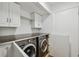 Convenient laundry room equipped with modern washer, dryer, and ample cabinet storage space at 6109 Schooner Way, Tampa, FL 33615