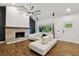 Stylish living room featuring wood floors, a modern ceiling fan, and a beautiful stone fireplace at 6109 Schooner Way, Tampa, FL 33615
