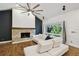 Modern living room featuring hardwood floors, a ceiling fan, fireplace, and ample natural light at 6109 Schooner Way, Tampa, FL 33615