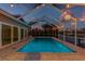 The home's waterfront pool is surrounded by lighting to create a serene outdoor evening space at 6109 Schooner Way, Tampa, FL 33615