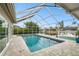 The pristine pool area offers privacy with screen enclosure overlooking waterway and boat dock at 6109 Schooner Way, Tampa, FL 33615