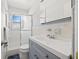 Modern bathroom with a sleek shower, white tile, and a gray vanity with silver hardware at 6950 12Th N Ave, St Petersburg, FL 33710