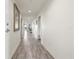 Long hallway with wood-look tile flooring leading to various rooms, bright and airy with neutral walls at 706 Bayway Blvd # 301, Clearwater Beach, FL 33767