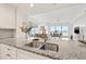 Granite countertops and a stainless steel sink are featured in this kitchen view overlooking the living room at 706 Bayway Blvd # 301, Clearwater Beach, FL 33767