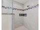 Modern shower featuring sleek tile, glass enclosure, and decorative mosaic accents at 706 Bayway Blvd # 301, Clearwater Beach, FL 33767