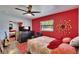 Bedroom with red walls, wood floors, and decorative wall decor at 725 Philippe Pkwy, Safety Harbor, FL 34695
