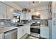 Well-equipped kitchen featuring white cabinets, modern appliances, and stylish backsplash at 725 Philippe Pkwy, Safety Harbor, FL 34695