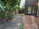 The backyard features a brick patio with tropical landscaping and privacy fence at 730 S Village N Dr # 101, St Petersburg, FL 33716