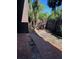 A brick patio in a fenced backyard with partial sunlight shining through the lush trees, offering a tranquil outdoor space at 730 S Village N Dr # 101, St Petersburg, FL 33716