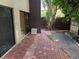 Outdoor patio with brick flooring, landscaping, and a small storage unit at 730 S Village N Dr # 101, St Petersburg, FL 33716
