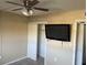 A bedroom featuring a ceiling fan, television, closet, and carpeted floors at 730 S Village N Dr # 101, St Petersburg, FL 33716
